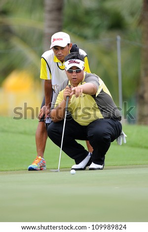 NAKHONPATHOM,THAILA ND-AUG 10: Kiradech Aphibarnrat of THA  with caddy lines up a shot during day two of the Golf Thailand Open at Suwan Golf Club on August 10, 2012 in Nakhonpathom Thailand