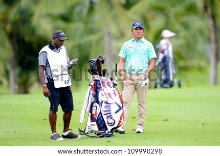 NAKHONPATHOM,THAILA ND - AUG 10:Danny Chia of MAL with caddy lines up a shot during hole9 day two of the Golf Thailand Open at Suwan Golf&Country Club on August 10, 2012 in Nakhonpathom Thailand