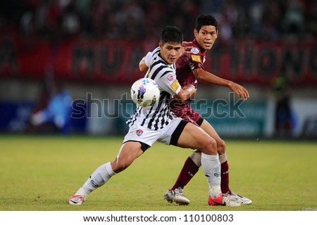 PATHUM THANI,THAILAND-AUG8: Mongkol Namnuad (White) in action  during Thai Premier League between Insee Police UTD.and SCG Muangthong UTD.at 	Thammasat Stadium on Aug 8,2012 in PathumThani, Thailand
