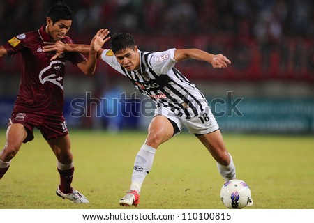 PATHUM THANI,THAILAND-AUG8: Mongkol Namnuad (White) play the ball during Thai Premier League between Insee Police UTD.and SCG Muangthong UTD.at 	Thammasat Stadium on Aug 8,2012 in Thailand