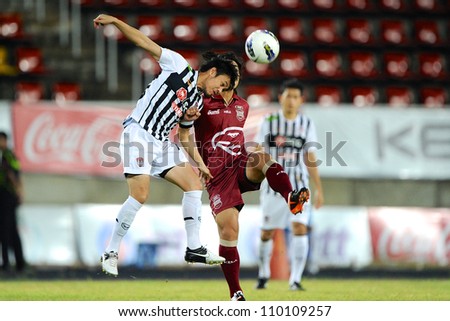 PATHUM THANI,THAILAND-AUG8:Pichitphong Choeichiu (White) for the ball during Thai Premier League between Insee Police UTD.and SCG Muangthong UTD.at 	Thammasat Stadium on Aug 8,2012 in Thailand