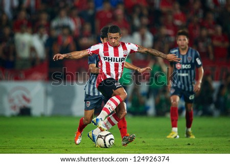 BANGKOK,THAILAND-JANUARY 8: Memphis Depay (RED) of PSV control the ball during The AIA Champions Cup match between SCG Muangthong Utd. and PSV at SCG Stadium on Jan8 ,2012 in ,Thailand.
