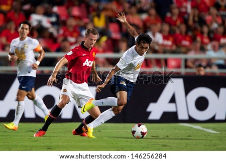 BANGKOK,THAILAND-JULY13:Teerasil Dangda(R)of Singha All Star XI in action during the friendly match between Singha All Star XI and Manchester United at Rajamangala Stadium on July13, 2013 in Thailand.
