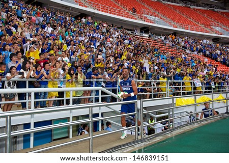 BANGKOK,THAILAND-JULY 16:Ashley Cole of Chelsea FC throws footballs to fans during a Chelsea FC training session at Rajamangala Stadium on July 16, 2013 in Bangkok, Thailand.