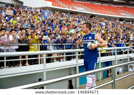 BANGKOK,THAILAND-JULY 16:John Terry of Chelsea FC throws footballs to fans during a Chelsea FC training session at Rajamangala Stadium on July 16, 2013 in Bangkok, Thailand.