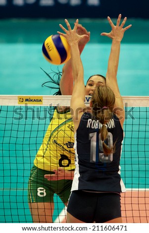 BANGKOK,THAILAND-AUGUST15:Jaqueline Carvalho (yellow)of Brazil spikes the ball during the FIVB Women\'s World Grand Prix 2014  Brazil and USA at Indoor Stadium Huamark on Aug.15, 2014 in Thailand.