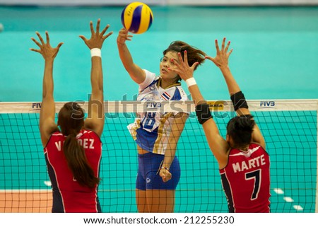 BANGKOK,THAILAND-AU GUST15:Ajcharaporn	 Kongyot (C)of Thailand spikes the ball during the FIVB World Grand Prix Thailand and Dominican Republic at Indoor Stadium Huamark on Aug.15, 2014 in Thailand.