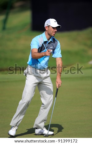 CHONBURI, THAILAND - DECEMBER 15:Charl Schwartzel of South Africa plays a shot during day one of the Thailand Golf Championship at Amata Spring Country Club on December 15, 2011 in Chonburi, Thailand.