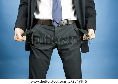 businessman showing empty pockets in pants