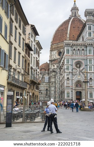 FLORENCE,ITALY-AUGUST 26,2014:two policeman control the situation in the Piazza del Duomo in Florence always full of tourists during a cloudy day