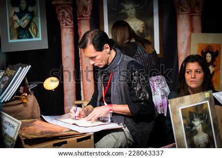 LUCCA,ITALY-NOVEMBER 3,2012:the fantasy artist Ciruelo performs his designs in the shop at the fair in Lucca