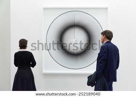 BOLOGNA,ITALY-JANUARY 24,2015:people walk and look at works of art in an exhibition while art experts answer all questions related to the artists on display.
