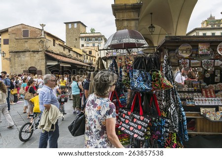 FLORENCE,ITALY-AUGUST 26,2014:Tourists stroll and shop among the many shops on the Ponte Vecchio in Florence during a cloudy day.