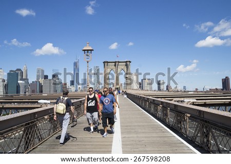 NEW YORK CITY,USA-AUGUST 4,2013:Tourists and New Yorkers cross the bridge brooklin during a sunny day.This bridge is one of the main tourist attractions of Manhattan.