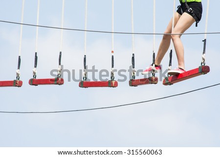 BOLOGNA,ITALY-MAY 31,2015:Group of people hanging on a equipped path walks among cordage, ropes and obstacles during a sunny day.