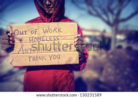 a homeless person with a sign