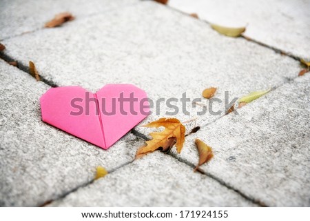 an origami heart on concrete paver blocks good for valentine\'s day or fall