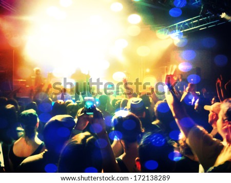 a crowd of people at a concert (focus on the phone photo)
