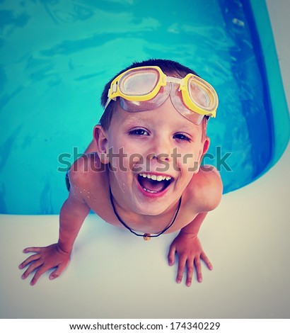 a young boy swimming in a small pool done with a vintage retro instagram filter