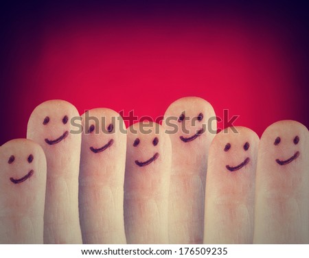 a group of cute smiling faces on fingers done with a retro vintage instagram filter