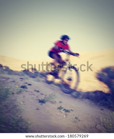 a woman on a mountain bike with a motion blur done with a retro vintage instagram filter