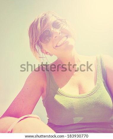 a cute girl smiling at the camera on a bright sunny day done with a retro vintage instagram filter
