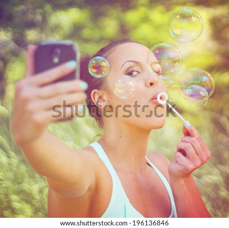 a pretty girl blowing bubbles - vintage toned with a retro instagram filter