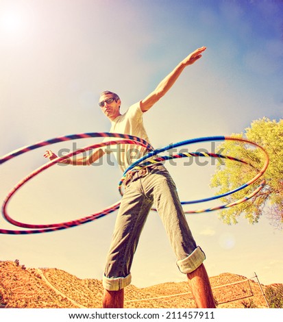 a young man hula hooping in a local park toned with a retro vintage instagram filter