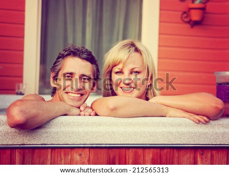 a young couple sitting in hot tub toned with a retro vintage instagram filter