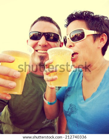 woman and a man celebrating over a fresh draft beer as their drink toned with a vintage retro style instagram filter