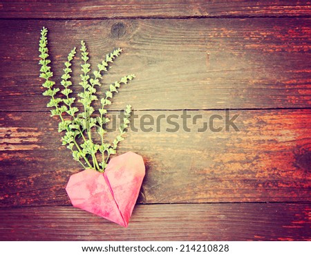 an origami heart on old fence boards - good for valentine\'s day or background design toned with a retro vintage instagram filter effect