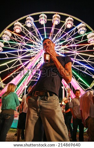 a young man making a funny face at a local state fair at night