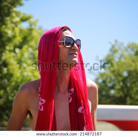 a man with a sarong on his head at a local park on a hot summer day
