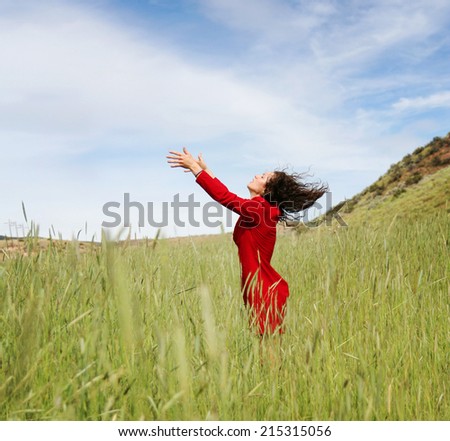 a girl walking in a field letting go