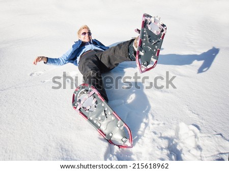 a woman playing in the snow with snow shoes on