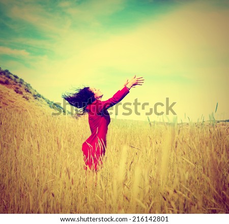 a girl walking in a field letting go of something toned with a retro vintage instagram filter effect