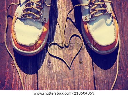 a pair of deck shoes on a nice wooden porch with the laces in a