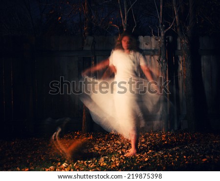 a woman in a very foggy forest at night with a yellow cat and motion blur caused by slow shutter speed