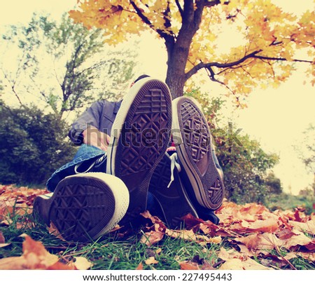 a family sitting under a tree with their feet in front toned with a retro vintage instagram filter