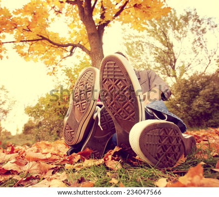 a family sitting under a tree with their feet in front toned with a retro vintage instagram filter  effect