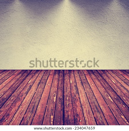 an image of an empty room with gray tones and a brown wood floor toned with a retro vintage instagram filter