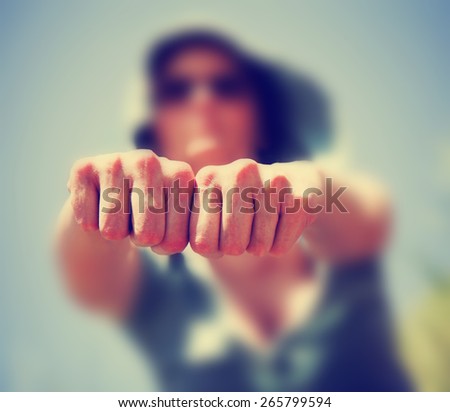 a blurred out woman holding her hands in fists toward the camera toned with a retro vintage instagram filter effect app or action