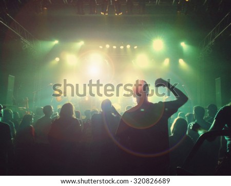 a crowd of people at a concert with a slight blur toned with a retro vintage instagram filter effect app or action