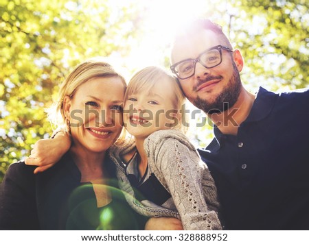 a cute family posing in a park toned with a retro vintage instagram filter effect app or action