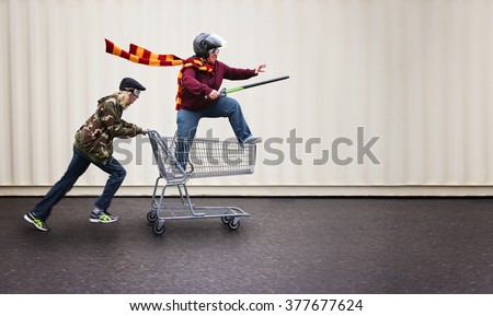 two people dressed up as super heroes or characters horsing around in a shopping cart with goggles and a helmet and sword