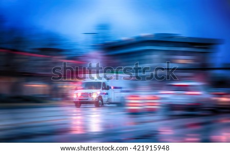 an ambulance racing through the rain on a stormy night with motion blur (NO SHARP FOCUS DUE TO RAIN and slow shutter speed) with reflections in the road