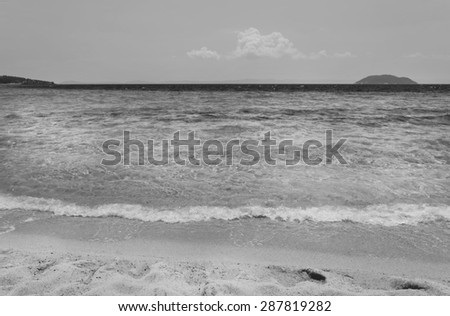 Wave of the sea on the sand beach black and white