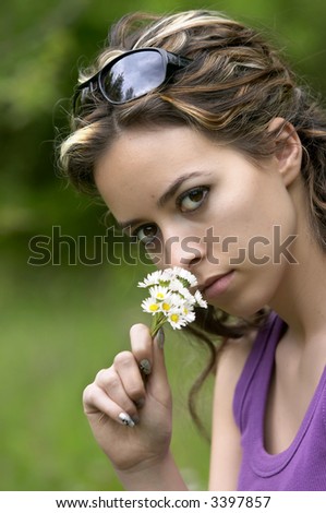 pretty girl smells white flower in nature