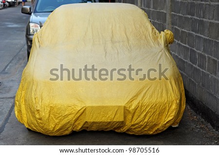 A car with cover sheet for sunlight, rain and dust protection