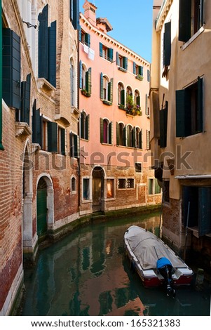 The boat is moored in the narrow canal of Venice
